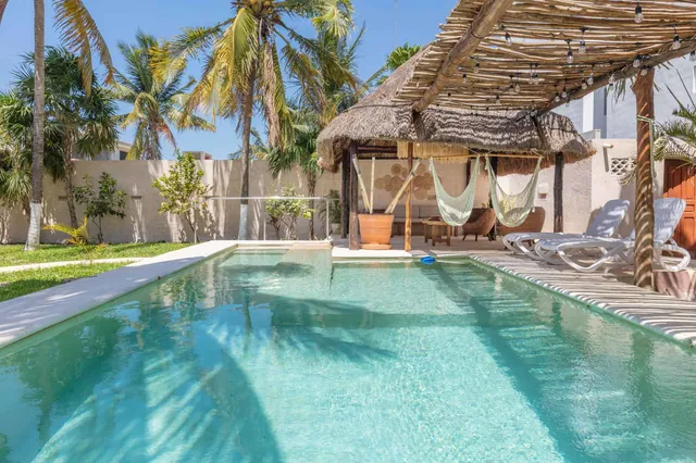 Alberca con palapa y hamacas en Hamaka Beach House