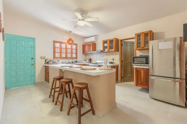 Cocina equipada con barra y bancos en Hamaka Beach House